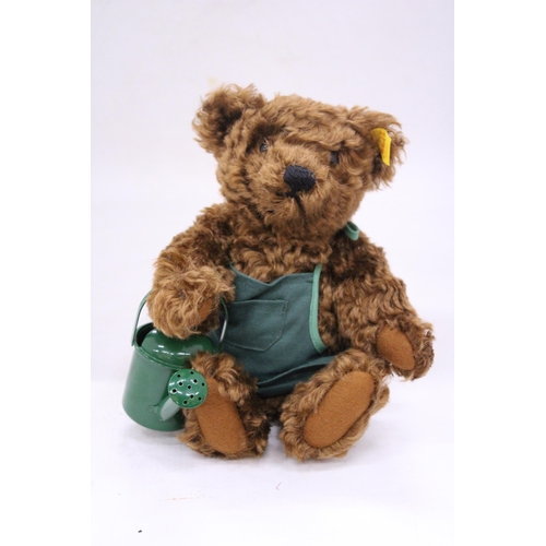 137 - A STEIFF 'GARDENER' SATURDAY TEDDY BEAR WITH APRON AND WATERING CAN AND BUTTON IN THE EAR