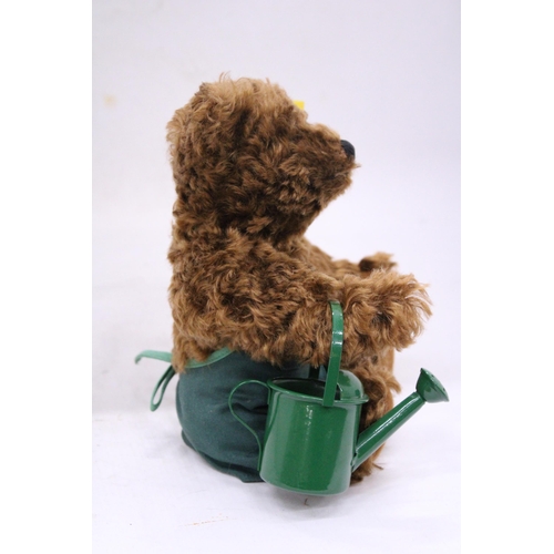 137 - A STEIFF 'GARDENER' TEDDY BEAR WITH APRON AND WATERING CAN AND BUTTON IN THE EAR