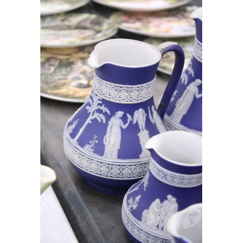 198 - SEVEN PIECES OF DARK BLUE WEDGWOOD JASPERWARE TO IONCLDE SIX JUGS OF VARYING SIZES AND A SUGAR BOWL