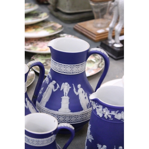 198 - SEVEN PIECES OF DARK BLUE WEDGWOOD JASPERWARE TO IONCLDE SIX JUGS OF VARYING SIZES AND A SUGAR BOWL