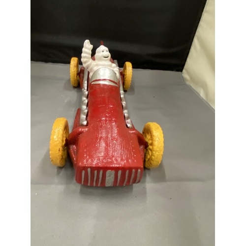 20 - A CAST MICHELIN MAN AVERTSING FIGURE DEPICTING MICHELIN MAN IN A RED RACING CAR 25CM LONG