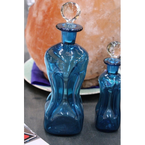 155 - TWO HOLMEGAARD KLUK-KLUK DECANTERS IN KINGFISHER BLUE WITH CLEAR STOPPERS, HEIGHTS 22CM AND 16CM