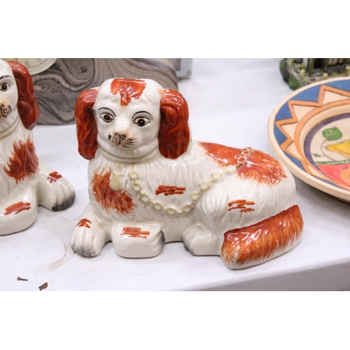 212 - A PAIR OF STAFFORDSHIRE SPANIELS, LYING DOWN