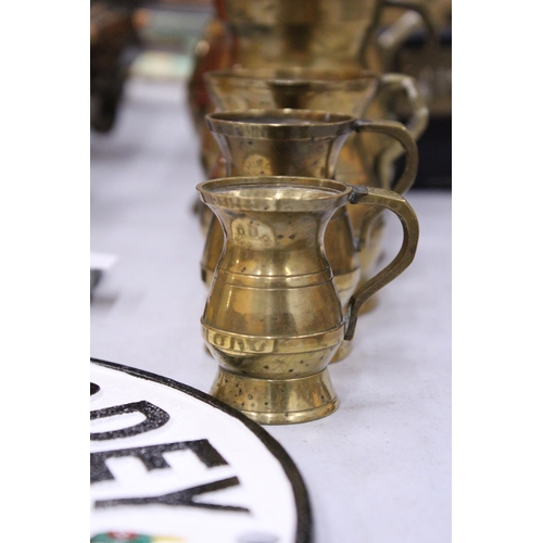 64 - A BRASS SET OF FIVE MEASURING TANKARDS