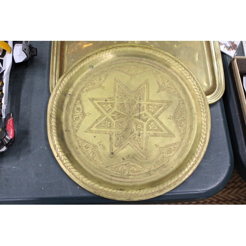 291 - AN ORNATE BRASS WALL PLAQUE AND A VICTORIAN BRASS TRAY