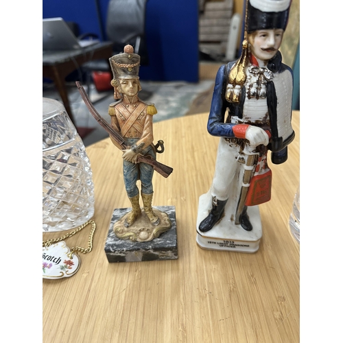 85 - TWO GLASS DECANTERS WITH THREE CERAMIC DECANTER LABELS, A RESIN SOLDIER ON A CARRARA MARBLE BASE AND... 