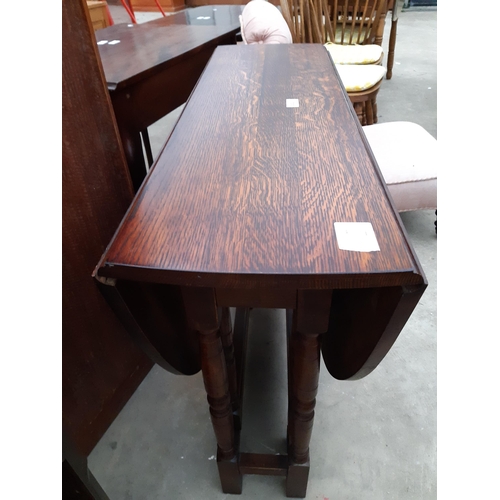 2621 - AN OVAL OAK GATE LEG TABLE ON TURNED LEGS, 53