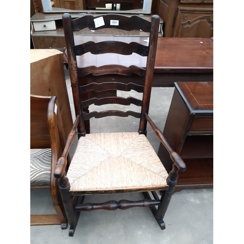 2623 - A 19TH CENTURY ELM LADDER BACK ROCKING CHAIR WITH RUSH SEAT