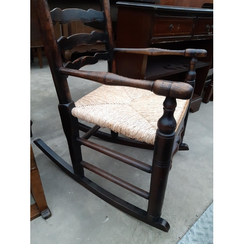 2623 - A 19TH CENTURY ELM LADDER BACK ROCKING CHAIR WITH RUSH SEAT