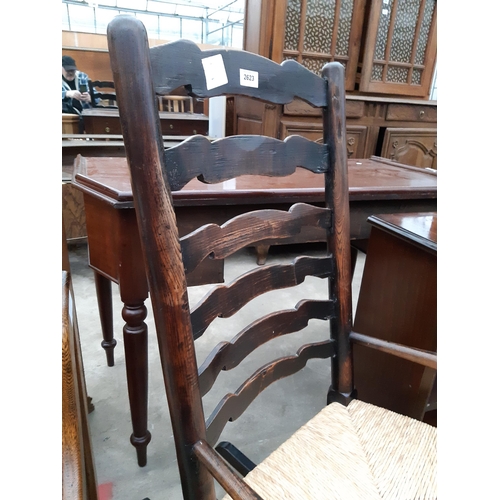 2623 - A 19TH CENTURY ELM LADDER BACK ROCKING CHAIR WITH RUSH SEAT