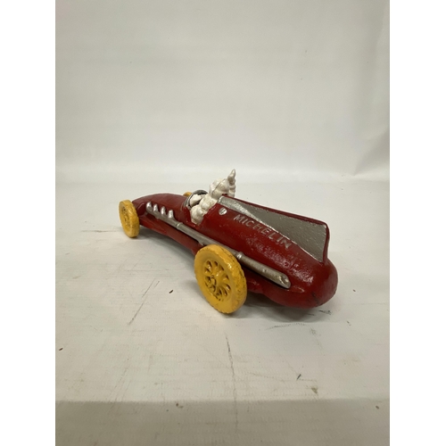 107 - A CAST MICHELIN MAN AVERTSING FIGURE DEPICTING MICHELIN MAN IN A RED RACING CAR 25CM LONG