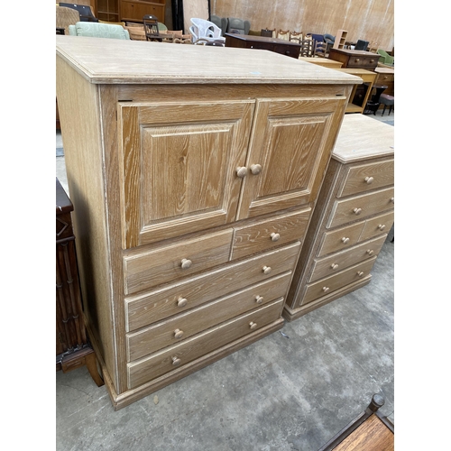 2792 - A LIMED OAK T.V. CABINET WITH SLIDING TOP DOORS AND DRAWERS TO BASE, 39.5