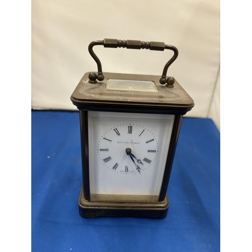 25 - A MATTHEW NORMAN BRASS CARRIAGE CLOCK WIT WHITE ENAMEL FACE, ROMAM NUMERALS AND VISUAL ESCAPEMENT