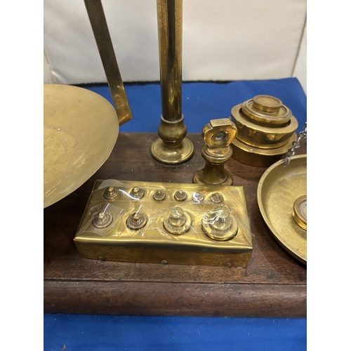 50 - A SET OF AGATE BRASS BALANCE SCALES ON A WOODEN BASE WITH VARIOUS WEIGHTS