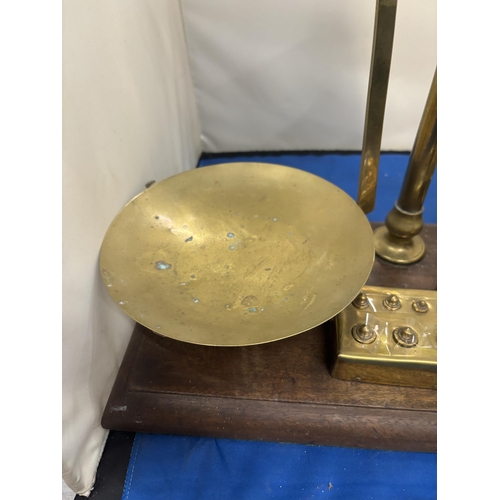 50 - A SET OF AGATE BRASS BALANCE SCALES ON A WOODEN BASE WITH VARIOUS WEIGHTS