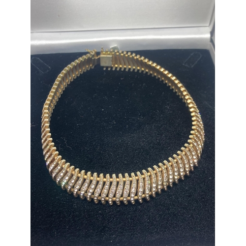 636 - A CLEARSTONE AND YELLOW METAL NECKLACE AND BRACELET SET IN A PRESENTATION BOX