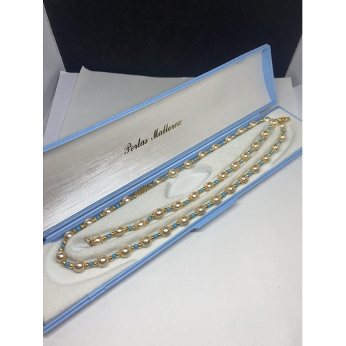 638 - A STRING OF PEARLS WITH BLUE AND YELLOW METAL BEADS AND A MATCHING BRACELET IN A PRESENTATION BOX