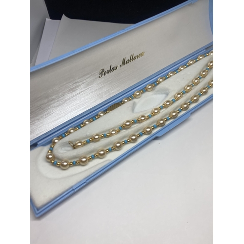 638 - A STRING OF PEARLS WITH BLUE AND YELLOW METAL BEADS AND A MATCHING BRACELET IN A PRESENTATION BOX