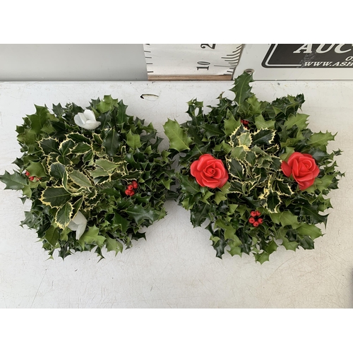 13 - TWO CHRISTMAS WREATHS WITH HOLLY AND CHRISTMAS ACCESSORIES ON A MOSS RING. APPROX 30CM IN DIAMETER T... 