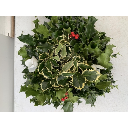 13 - TWO CHRISTMAS WREATHS WITH HOLLY AND CHRISTMAS ACCESSORIES ON A MOSS RING. APPROX 30CM IN DIAMETER T... 