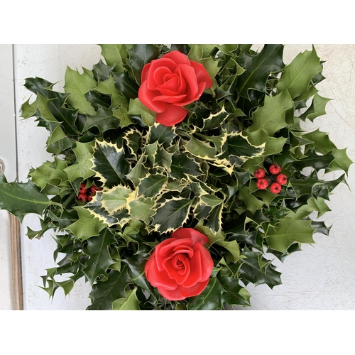 13 - TWO CHRISTMAS WREATHS WITH HOLLY AND CHRISTMAS ACCESSORIES ON A MOSS RING. APPROX 30CM IN DIAMETER T... 