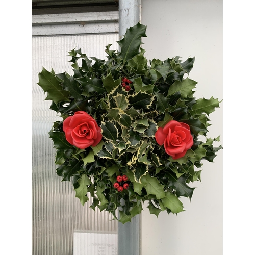 13 - TWO CHRISTMAS WREATHS WITH HOLLY AND CHRISTMAS ACCESSORIES ON A MOSS RING. APPROX 30CM IN DIAMETER T... 