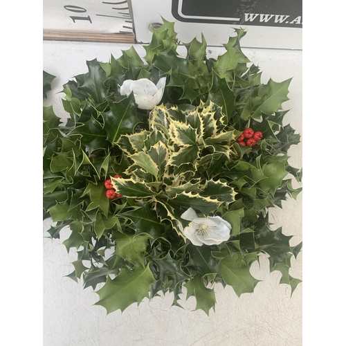 19 - TWO CHRISTMAS WREATHS WITH HOLLY, RIBBON AND CHRISTMAS ACCESSORIES ON A MOSS RING. APPROX 30CM IN DI... 