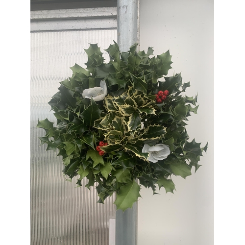 19 - TWO CHRISTMAS WREATHS WITH HOLLY, RIBBON AND CHRISTMAS ACCESSORIES ON A MOSS RING. APPROX 30CM IN DI... 