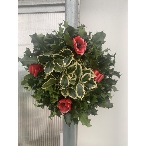 19 - TWO CHRISTMAS WREATHS WITH HOLLY, RIBBON AND CHRISTMAS ACCESSORIES ON A MOSS RING. APPROX 30CM IN DI... 