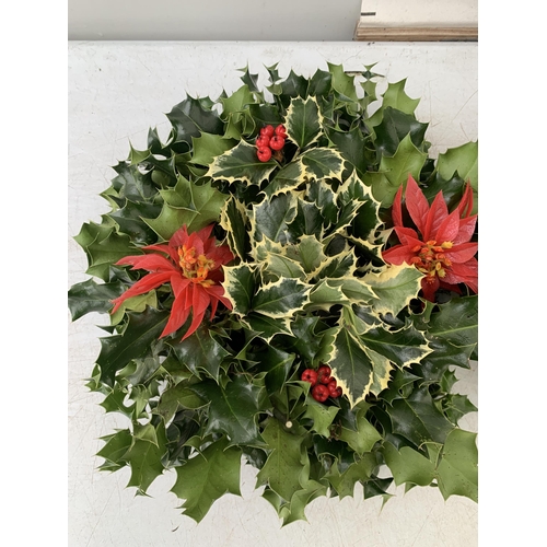 22 - TWO CHRISTMAS WREATHS WITH HOLLY AND CHRISTMAS ACCESSORIES ON A MOSS RING. APPROX 30CM IN DIAMETER T... 