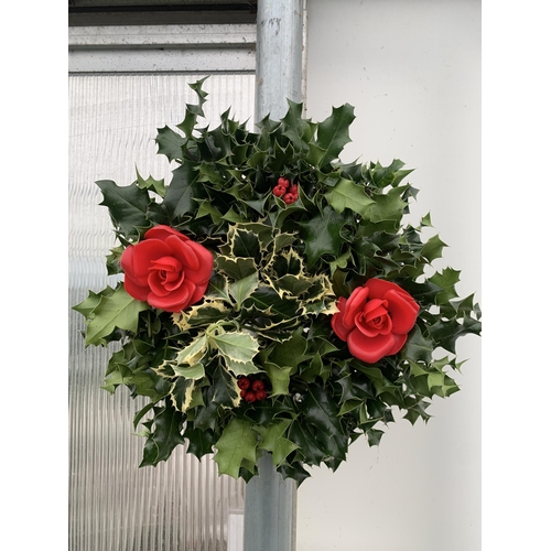 22 - TWO CHRISTMAS WREATHS WITH HOLLY AND CHRISTMAS ACCESSORIES ON A MOSS RING. APPROX 30CM IN DIAMETER T... 