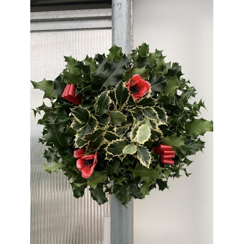 31 - TWO CHRISTMAS WREATHS WITH HOLLY, RIBBON AND CHRISTMAS ACCESSORIES ON A MOSS RING. APPROX 30CM IN DI... 