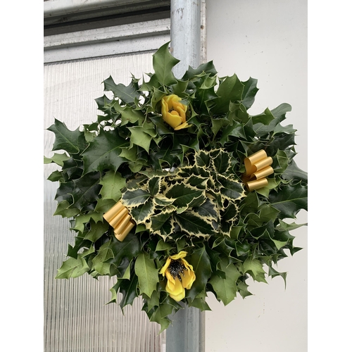 31 - TWO CHRISTMAS WREATHS WITH HOLLY, RIBBON AND CHRISTMAS ACCESSORIES ON A MOSS RING. APPROX 30CM IN DI... 