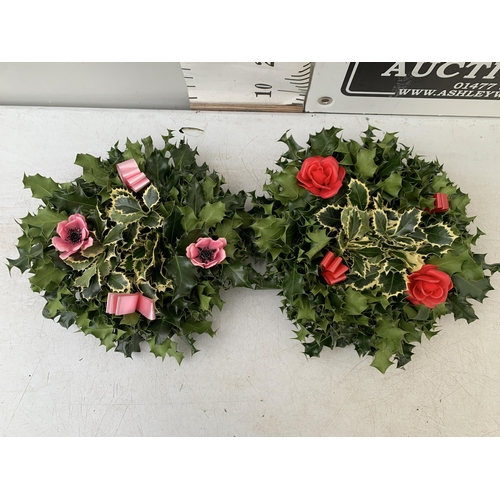 35 - TWO CHRISTMAS WREATHS WITH HOLLY, RIBBON AND CHRISTMAS ACCESSORIES ON A MOSS RING. APPROX 30CM IN DI... 