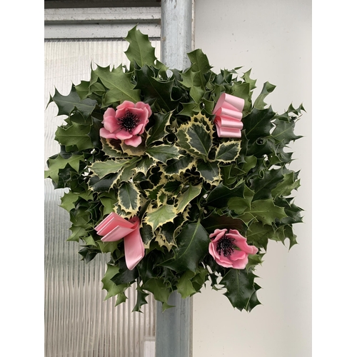 35 - TWO CHRISTMAS WREATHS WITH HOLLY, RIBBON AND CHRISTMAS ACCESSORIES ON A MOSS RING. APPROX 30CM IN DI... 