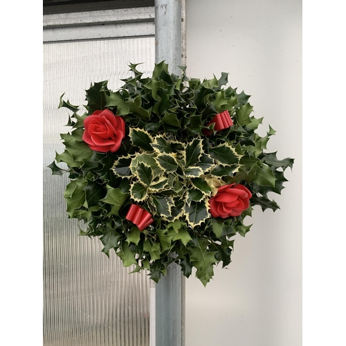 35 - TWO CHRISTMAS WREATHS WITH HOLLY, RIBBON AND CHRISTMAS ACCESSORIES ON A MOSS RING. APPROX 30CM IN DI... 