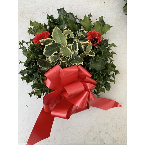 9 - TWO CHRISTMAS WREATHS WITH HOLLY, RIBBON AND CHRISTMAS ACCESSORIES ON A MOSS RING. APPROX 30CM IN DI... 