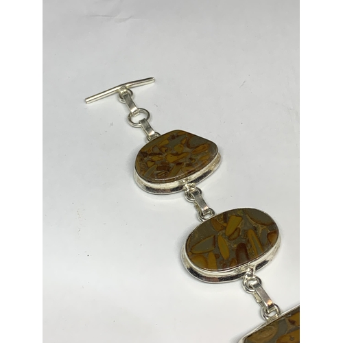 711 - A MARKED SILVER BRACELET WITH FIVE VARIOUS SHAPED JASPER STONES