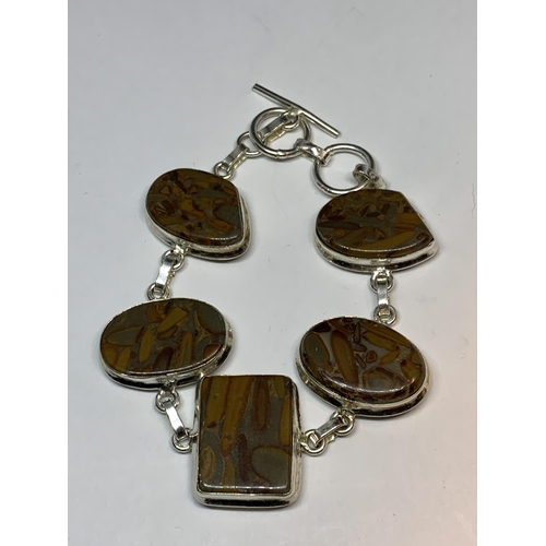 711 - A MARKED SILVER BRACELET WITH FIVE VARIOUS SHAPED JASPER STONES