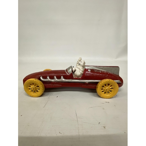 107 - A CAST MICHELIN MAN AVERTSING FIGURE DEPICTING MICHELIN MAN IN A RED RACING CAR 25CM LONG