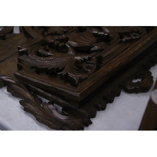 262 - A CARVED MAHOGANY WALL HANGING MAGAZINE/LETTER RACK WITH GRIFFIN DESIGN, 36CM X 40CM