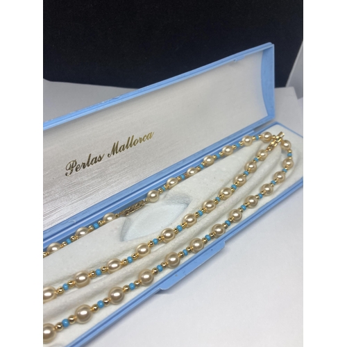 638 - A STRING OF PEARLS WITH BLUE AND YELLOW METAL BEADS AND A MATCHING BRACELET IN A PRESENTATION BOX