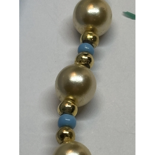 646 - A STRING OF PEARLS WITH BLUE AND YELLOW METAL BEADS AND A MATCHING BRACELET IN A PRESENTATION BOX AN... 