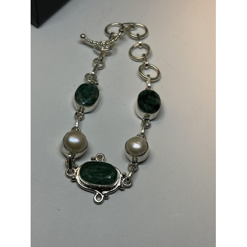 661 - A MARKED SILVER EMERALD AND PEARL BRACELET IN A PRESENTATION BOX