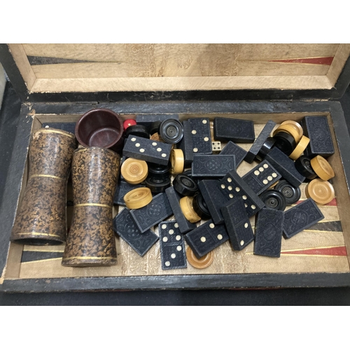 15 - A VINTAGE CHESS, DRAUGHTS, BACKGAMMON BOX BOARD WITH A QUANTITY OF VARIOUS COUNTERS, SHAKERS, DICE E... 