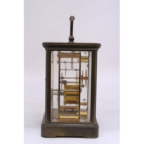 265 - A MATTHEW NORMAN BRASS CARRIAGE CLOCK WIT WHITE ENAMEL FACE, ROMAM NUMERALS AND VISUAL ESCAPEMENT