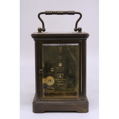 265 - A MATTHEW NORMAN BRASS CARRIAGE CLOCK WIT WHITE ENAMEL FACE, ROMAM NUMERALS AND VISUAL ESCAPEMENT