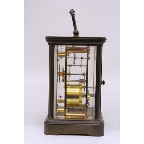 265 - A MATTHEW NORMAN BRASS CARRIAGE CLOCK WIT WHITE ENAMEL FACE, ROMAM NUMERALS AND VISUAL ESCAPEMENT