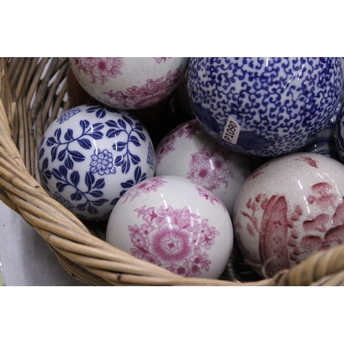 278 - A COLLECTION OF VARIOUS SIZES OF PATTERNED CERAMIC BALLS IN A BASKET