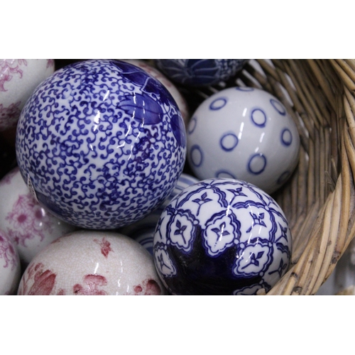 278 - A COLLECTION OF VARIOUS SIZES OF PATTERNED CERAMIC BALLS IN A BASKET